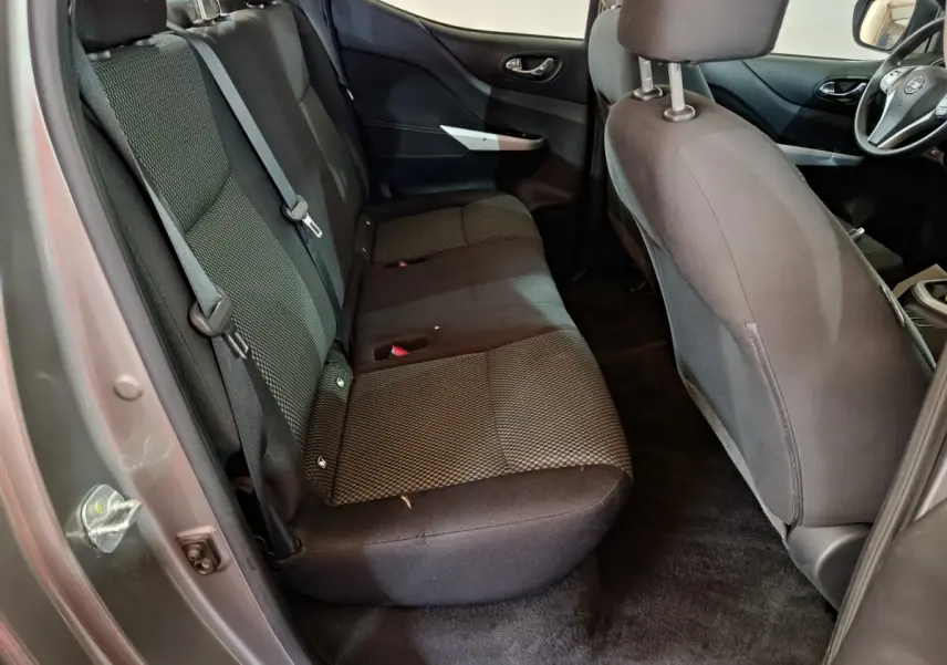 Vue intérieure côté gauche montrant la banquette arrière noire du Nissan Navara Double-Cab gris clair 2018.