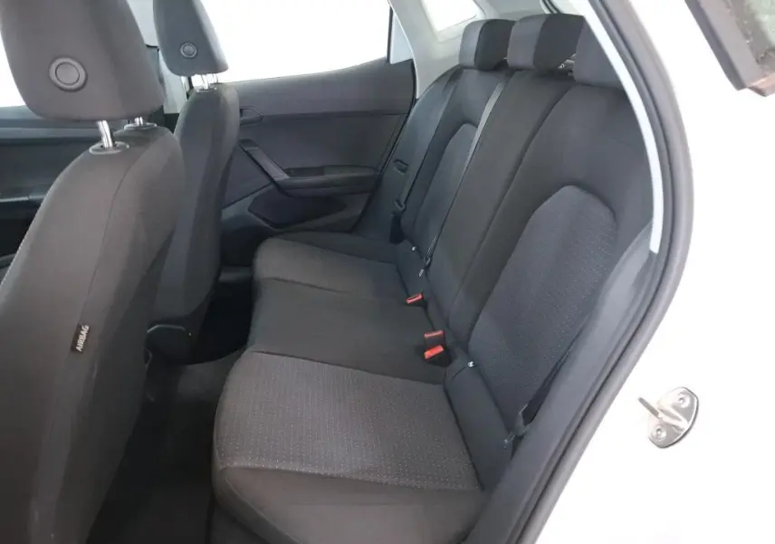 Vue rapprochée des commandes de lève-vitres et réglage des rétroviseurs sur la porte côté gauche d'une SEAT Ibiza blanche.
