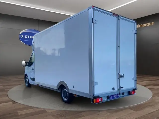 Renault Master blanc en 3/4 arrière droit, grand fourgon utilitaire avec caisse fermée et portes arrière battantes.