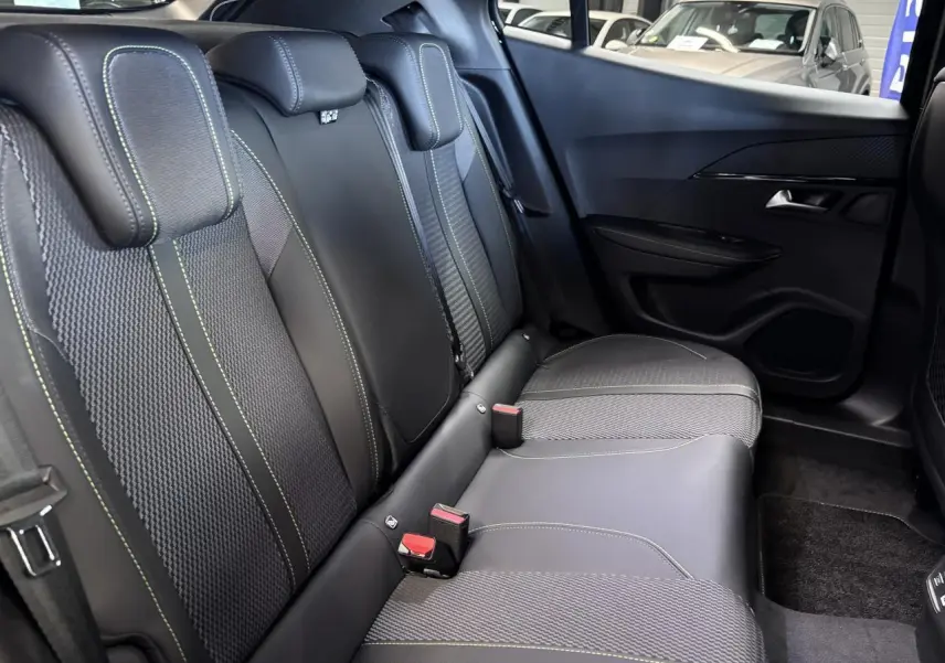 Vue latérale droite de la banquette arrière noire avec surpiqûres vertes du Peugeot 2008 1.2i Hybrid GT 2026.