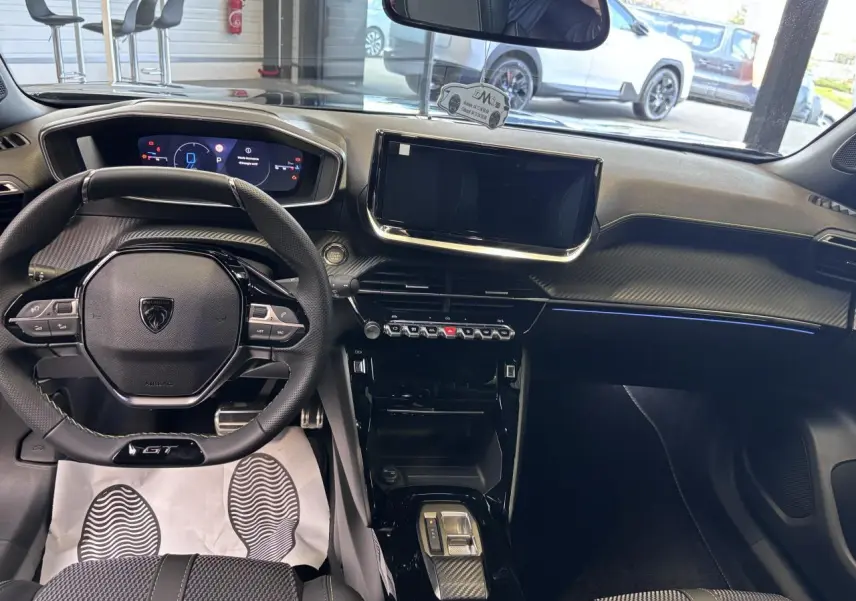 Vue intérieure avant du Peugeot 2008 GT hybride noire, avec tableau de bord numérique et écran tactile central.