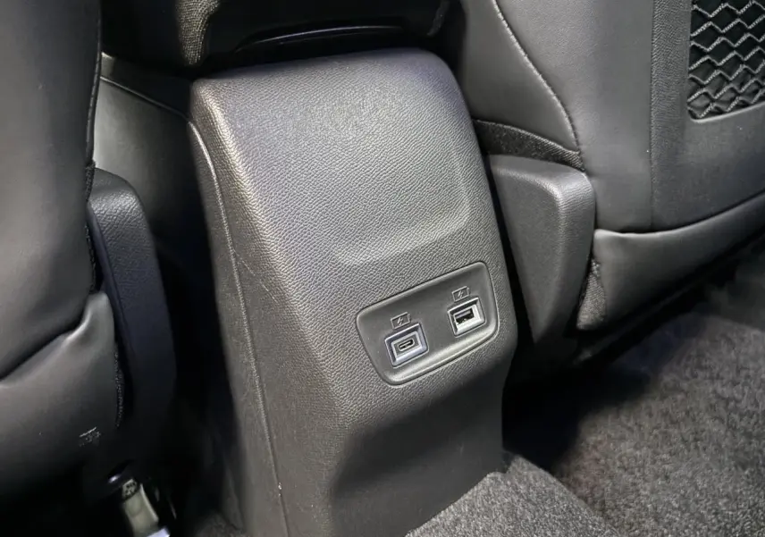 Prise USB type C et USB type A pour passagers arrière sur console centrale noire du Peugeot 2008 GT hybride 2026.