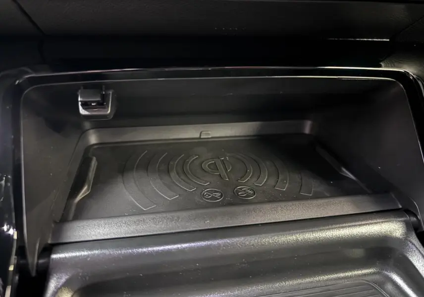 Gros plan sur le chargeur à induction noir dans la console centrale du Peugeot 2008 1.2i Hybrid GT 2026.