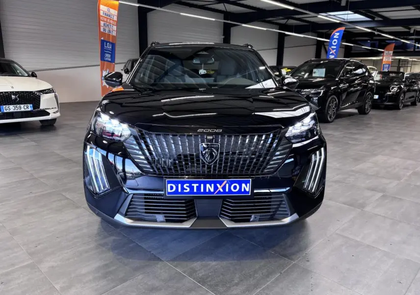 Vue avant d'un Peugeot 2008 noir brillant avec calandre verticale et feux LED en griffes, en showroom.