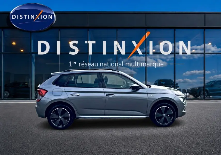 Profil droit du Skoda Kamiq gris graphite 2026 avec jantes alu noires et toit panoramique en verre visible.