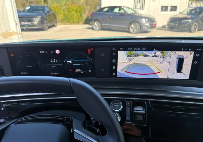 Vue intérieure du tableau de bord du Peugeot 5008 Hybrid 145 ch 2025, avec écran numérique et caméra de recul affichée.
