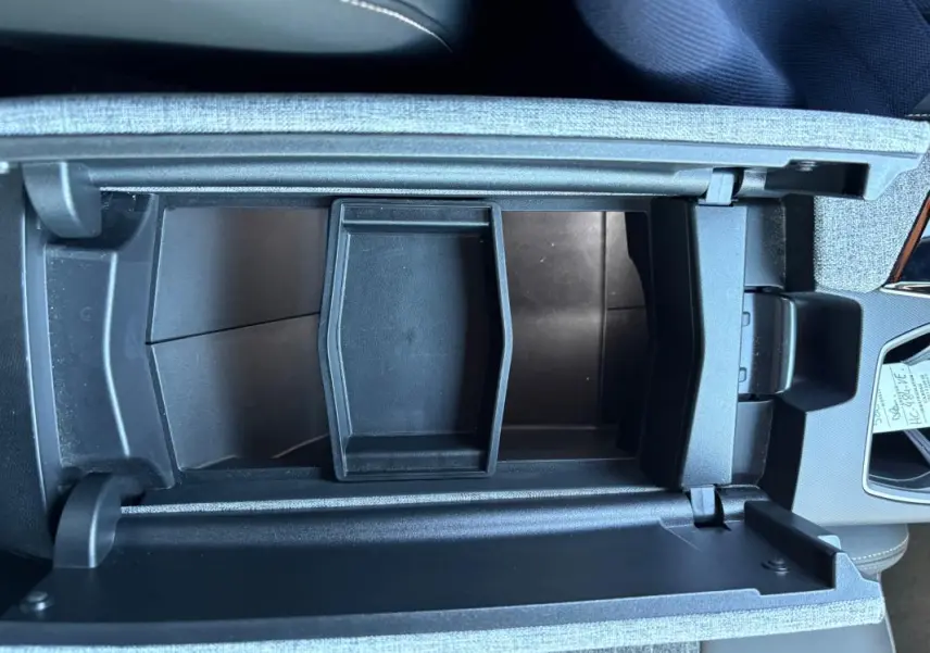 Vue plongeante sur le rangement central ouvert du Peugeot 5008 bleu foncé, version Hybrid 145 ch e-DCS6 Allure 2025.