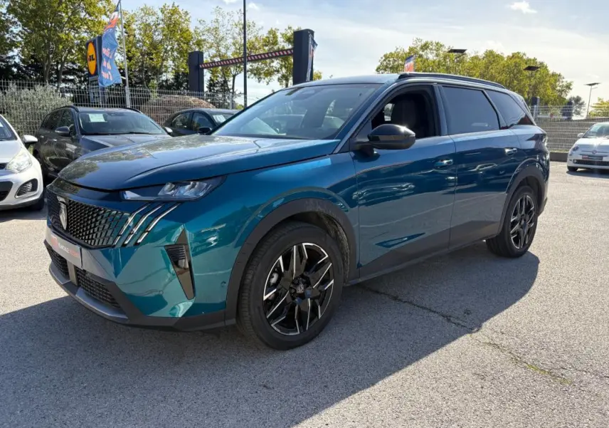 Peugeot 5008 Hybrid bleu foncé en 3/4 avant droit, avec calandre distinctive et jantes noires stylées.