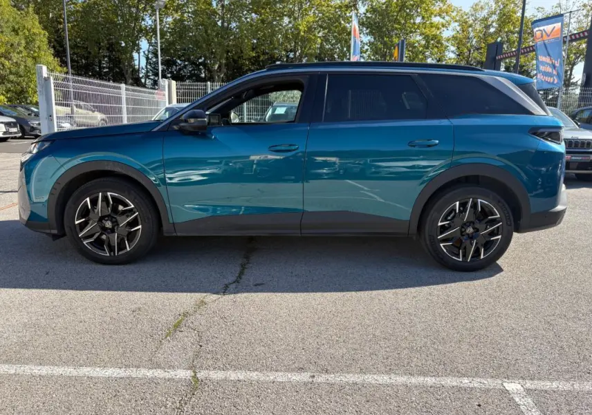 Vue de profil côté gauche d’un Peugeot 5008 Hybrid 145 ch e-DCS6 Allure bleu foncé avec jantes noires et toit noir.