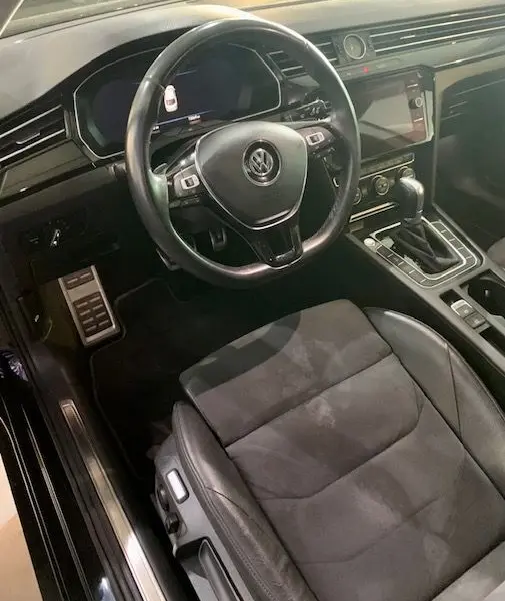 Intérieur noir du Volkswagen Arteon 2019, vue côté conducteur sur le volant, siège et console centrale avec boîte auto.