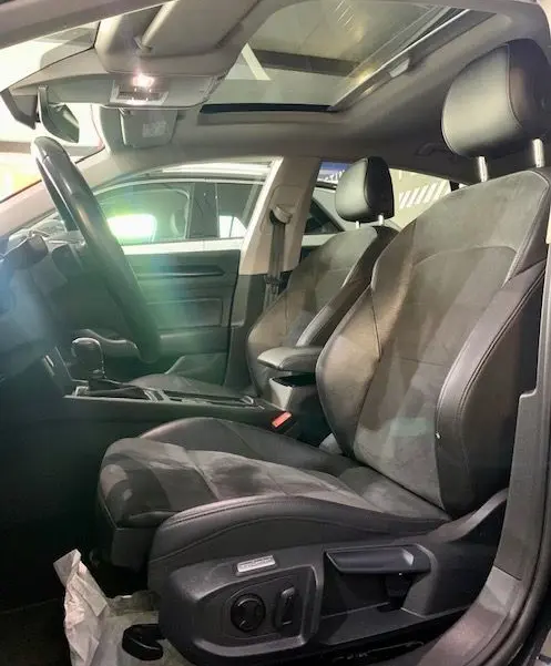 Intérieur du Volkswagen Arteon 2019, sièges avant en cuir et alcantara, toit ouvrant panoramique visible côté conducteur.