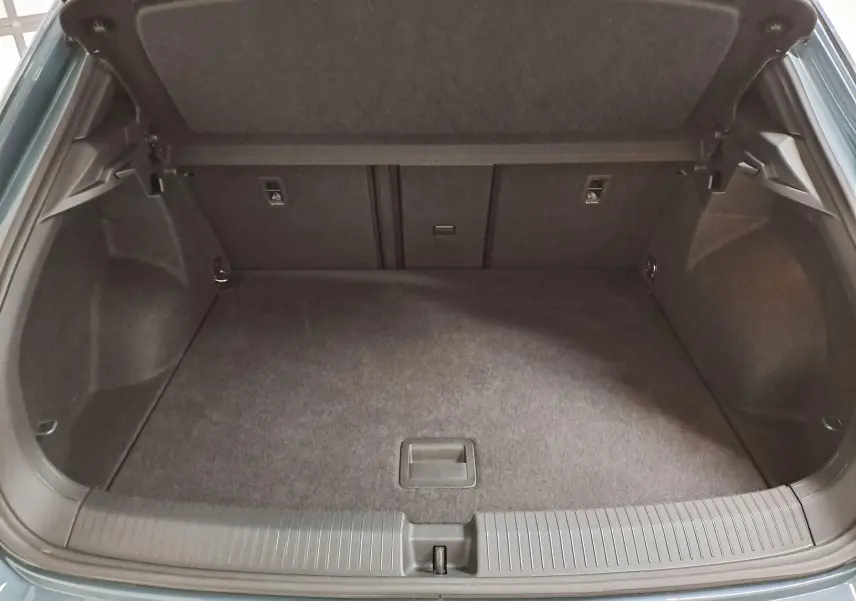 Coffre ouvert du Volkswagen T-Roc bleu pétrole 2025, vue plongeante montrant l'espace de chargement vide et les finitions intérieures.
