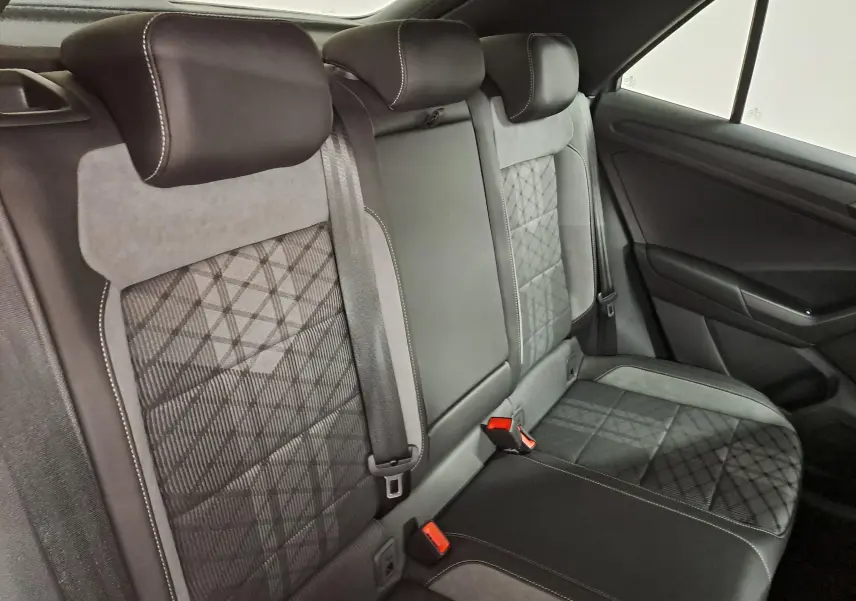 Vue intérieure du siège arrière droit du Volkswagen T-Roc 2025, avec sellerie tissu et cuir noir à motifs géométriques.