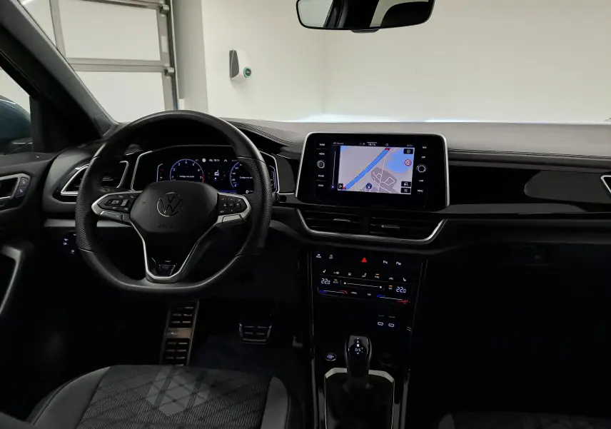 Vue intérieure du tableau de bord du Volkswagen T-Roc 1.5 TSI 150 DSG7 R-Line Edition avec écran tactile et volant multifonction.