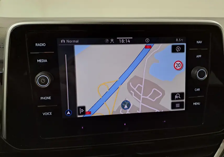 Écran tactile central du Volkswagen T-Roc 1.5 TSI bleu pétrole, affichant la navigation avec carte et options autour.