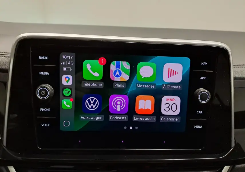 Écran tactile central du Volkswagen T-Roc 2025 affichant Apple CarPlay avec icônes colorées, vue de face.