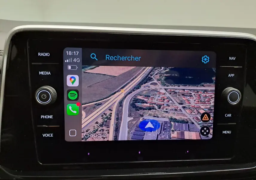 Écran tactile central du Volkswagen T-Roc 2025 affichant la navigation GPS avec vue satellite et commandes autour.