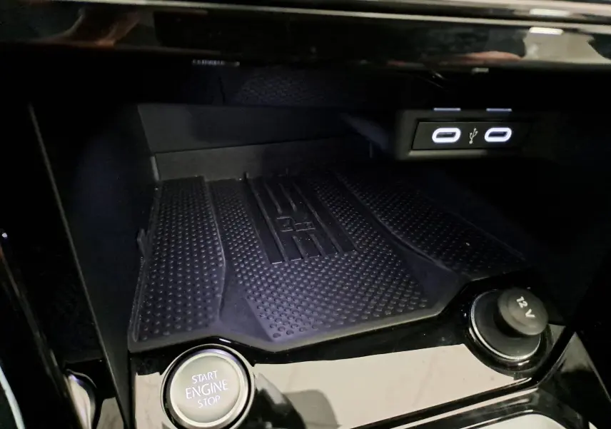 Gros plan intérieur sur la console centrale du Volkswagen T-Roc 2025 avec bouton start/stop et ports USB éclairés.