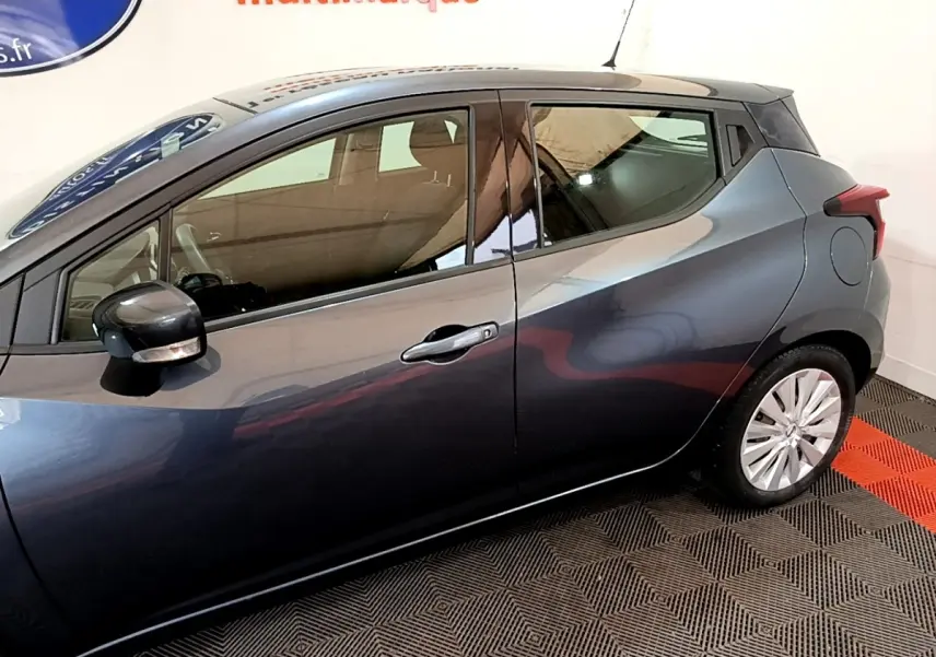 Profil côté gauche d'une Nissan Micra IG-T 100 Business Edition gris foncé, avec rétroviseur électrique et poignées chromées.