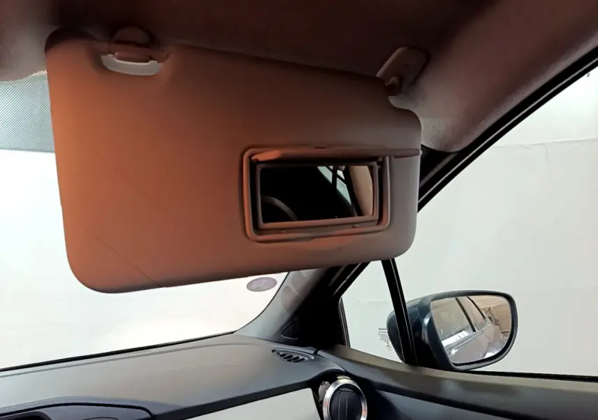 Intérieur de la Nissan Micra Business Edition 2020, vue côté passager avec pare-soleil rabattable et rétroviseur extérieur visible.