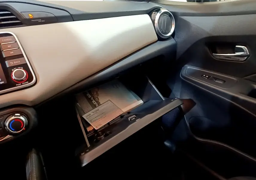 Intérieur côté passager de la Nissan Micra IG-T 100 Business Edition 2020, boîte à gants ouverte et tableau de bord gris clair.