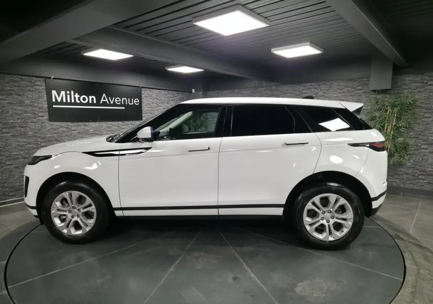 Range Rover Evoque blanc vu de profil côté gauche, avec jantes 18 pouces et toit noir contrasté.