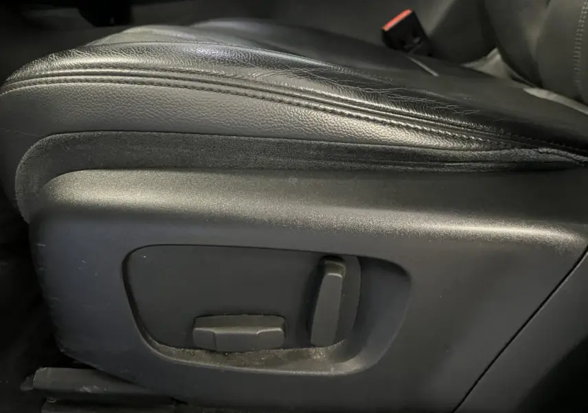 Gros plan sur les commandes électriques du siège avant en cuir noir du Range Rover Evoque 2020.