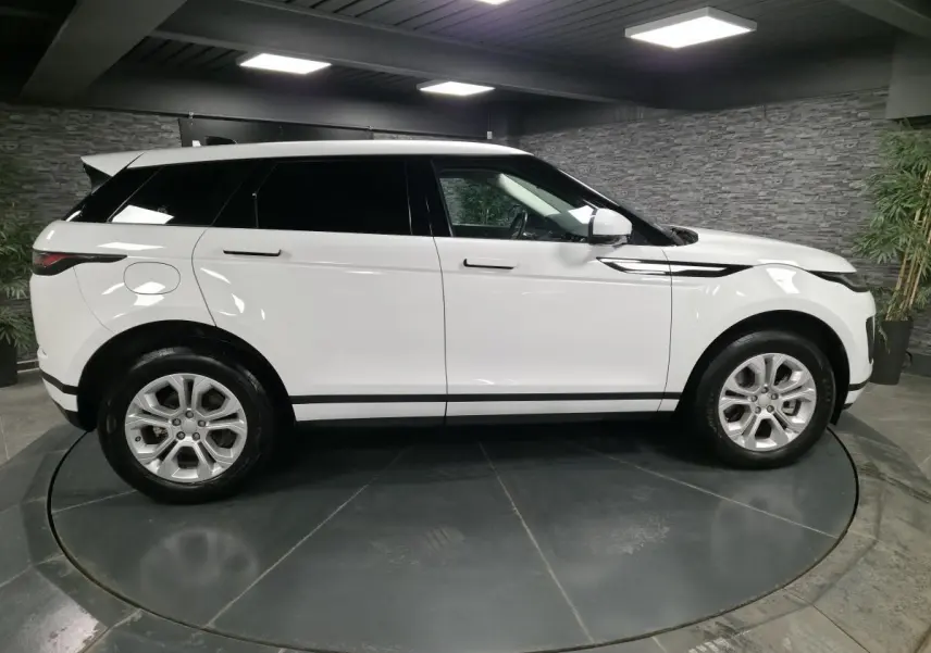 Vue de profil côté gauche d'un Range Rover Evoque blanc 2020 avec jantes 18 pouces et toit assorti.