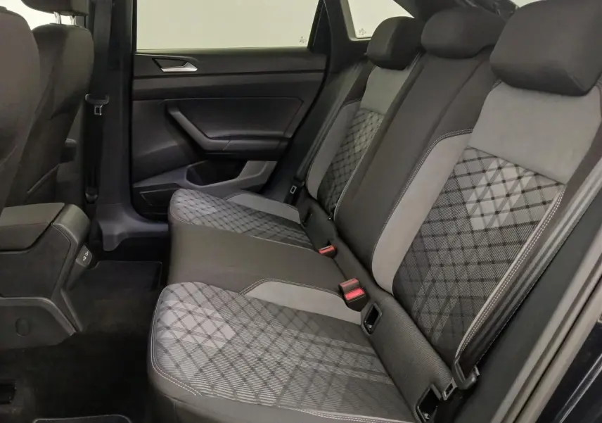 Vue latérale intérieure des sièges arrière du Volkswagen Taigo 2025, tissu noir et gris à motifs géométriques.