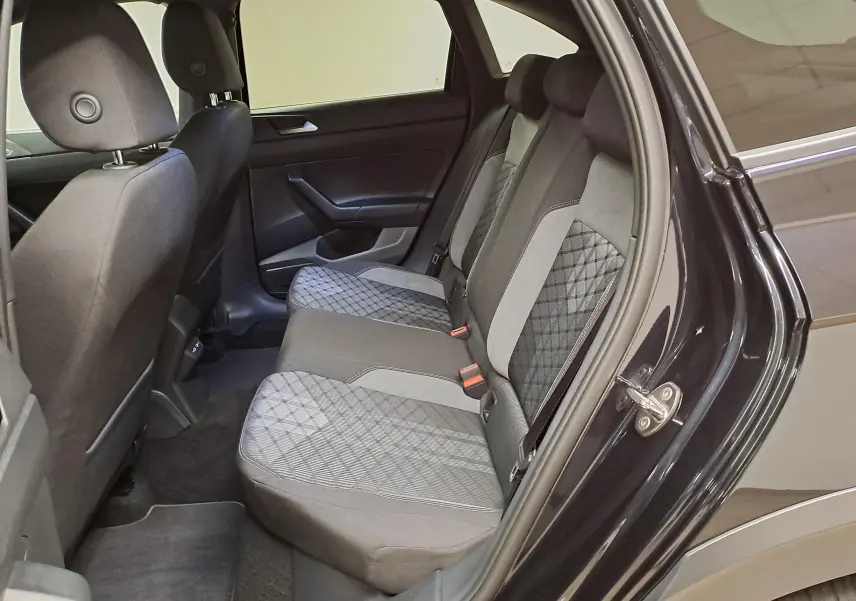 Vue intérieure côté droit des sièges arrière du Volkswagen Taigo 2025 noir intense nacré avec sellerie tissu à motifs géométriques.