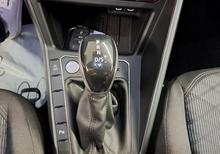 Gros plan sur le levier de vitesses automatique noir et cuir du Volkswagen Taigo 1.5 TSI R-Line Edition, intérieur sombre.