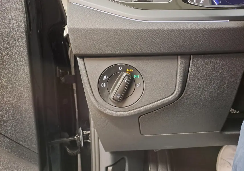 Gros plan sur le bouton de commande des phares du Volkswagen Taigo 1.5 TSI 150 DSG7 R-Line Edition noir intense nacré.