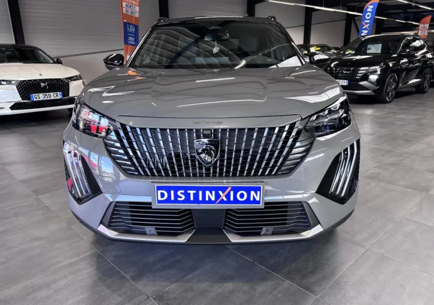 Vue avant d'un Peugeot 2008 gris selenium avec calandre noire verticale et feux LED distinctifs en forme de griffes.