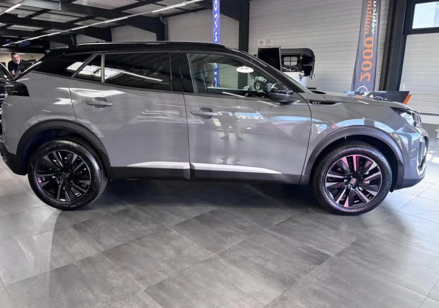 Peugeot 2008 1.2i Hybrid gris selenium vue profil droit, jantes alliage bi-ton noir et toit noir brillant.