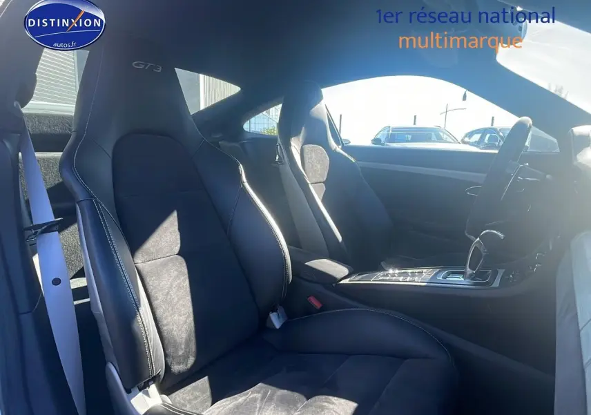 Intérieur vu côté droit de la Porsche 911 GT3 blanc, sièges sport cuir/alcantara noirs avec surpiqûres blanches.