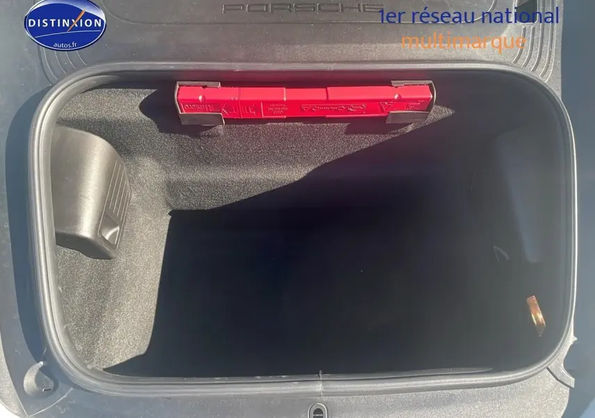 Vue plongeante sur le coffre avant ouvert d'une Porsche 911 GT3 blanche, avec triangle de signalisation rouge visible.