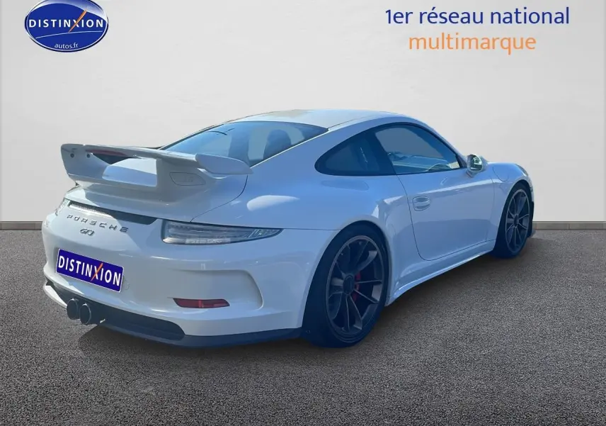 Vue 3/4 arrière droite d'une Porsche 911 (991) GT3 blanche avec becquet arrière et jantes noires.