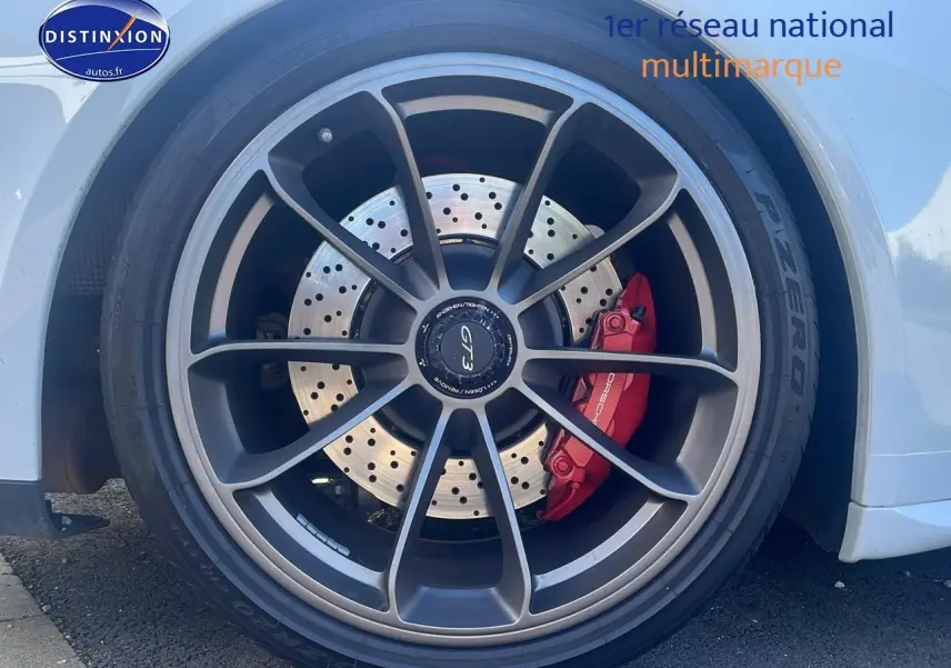 Gros plan sur la roue avant droite blanche d'une Porsche 911 GT3 991 avec étrier de frein rouge et jante alu grise.