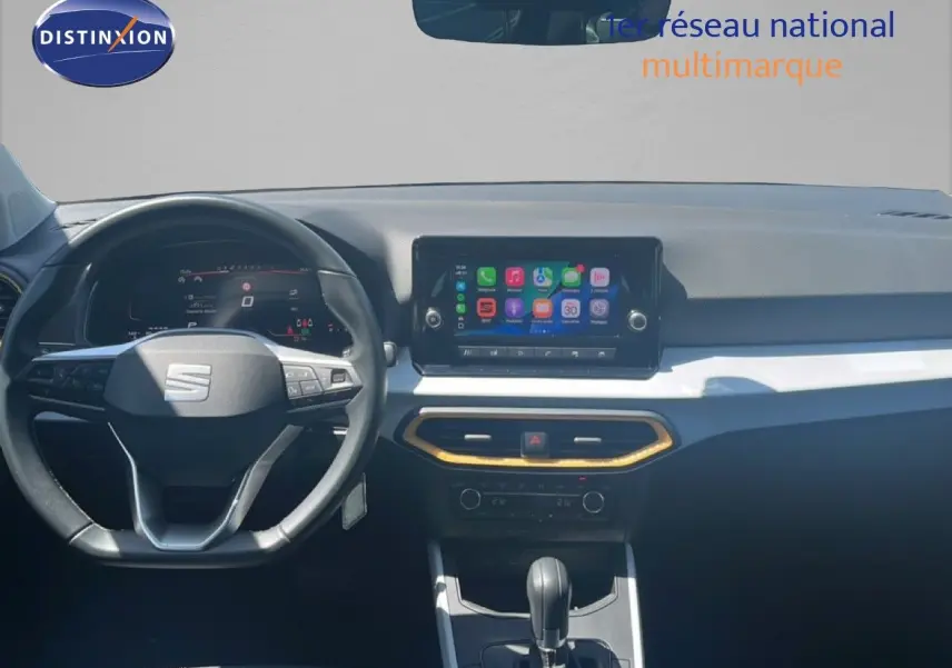Vue intérieure frontale du tableau de bord du SEAT Arona 2025 avec écran tactile et volant multifonction noir.