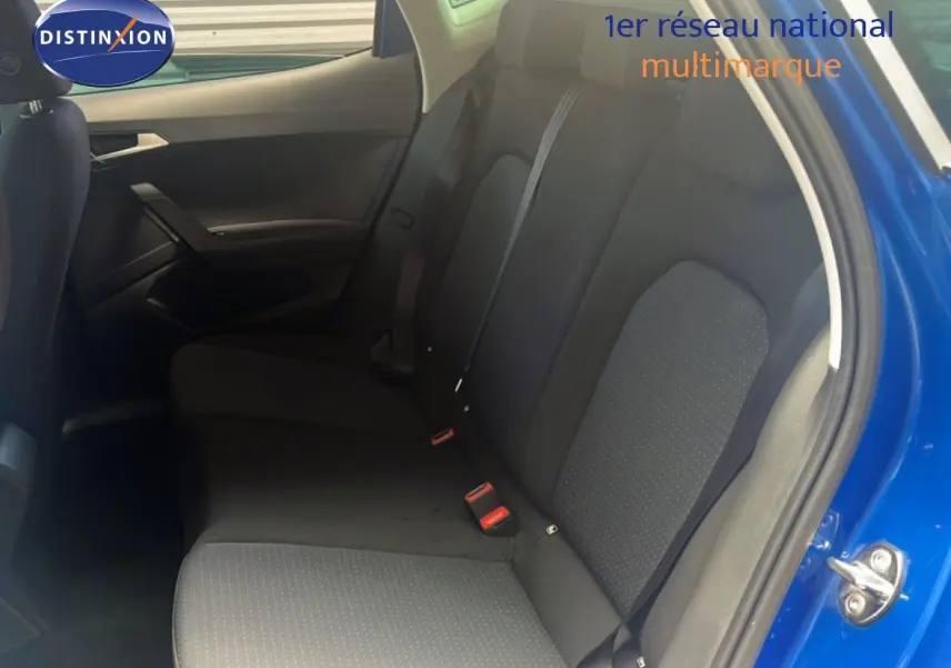 Vue intérieure côté droit des sièges arrière en tissu noir du SEAT Arona bleu saphir métallisé avec porte ouverte.
