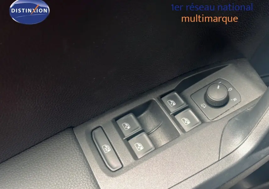Gros plan sur les commandes des vitres et rétroviseurs côté conducteur d’un SEAT Arona bleu saphir 2025.