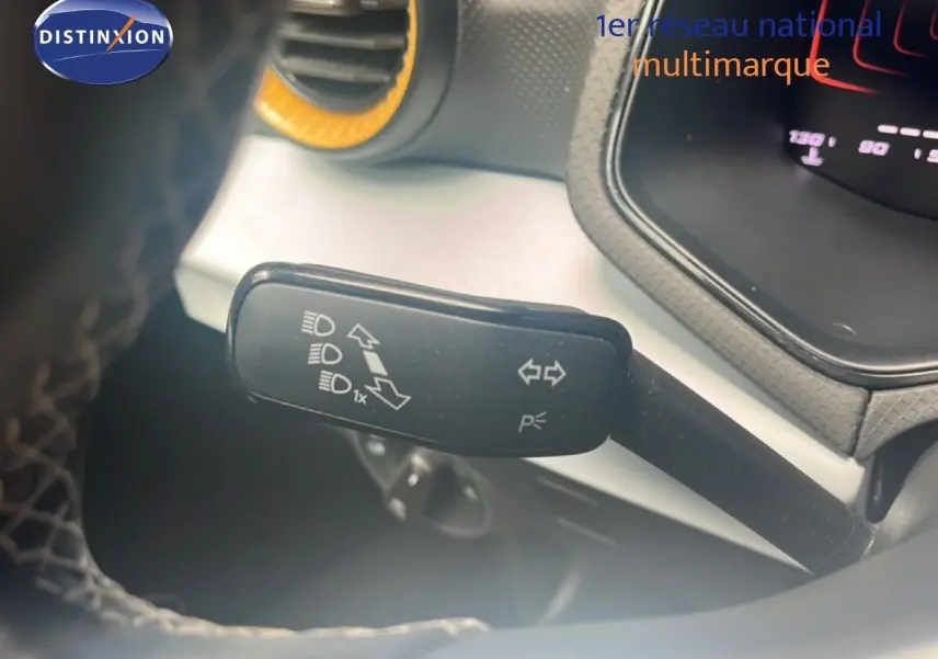 Gros plan sur la manette de clignotant et feux du tableau de bord d’un SEAT Arona 2025 bleu saphir métal.