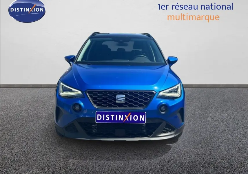 Vue avant d'un SEAT Arona bleu saphir métal avec toit noir, mettant en valeur sa calandre et ses phares LED distinctifs.