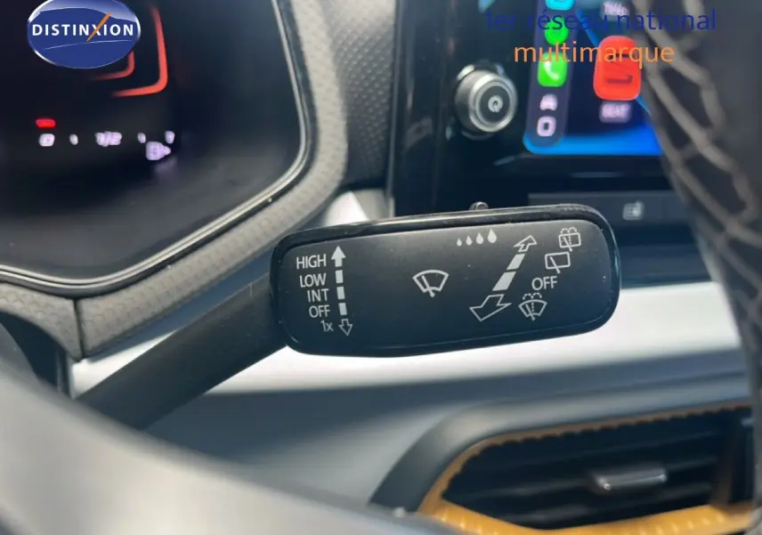 Gros plan sur la commande d’essuie-glace côté droit du tableau de bord d’un SEAT Arona 2025 bleu saphir métal.
