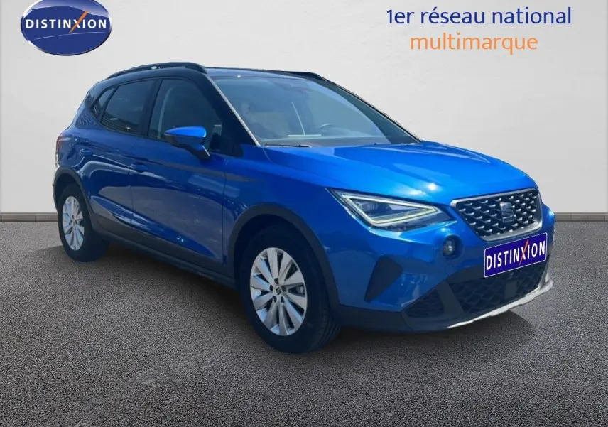 SEAT Arona bleu saphir métal avec toit noir, vue 3/4 avant droit, calandre et optiques LED visibles.