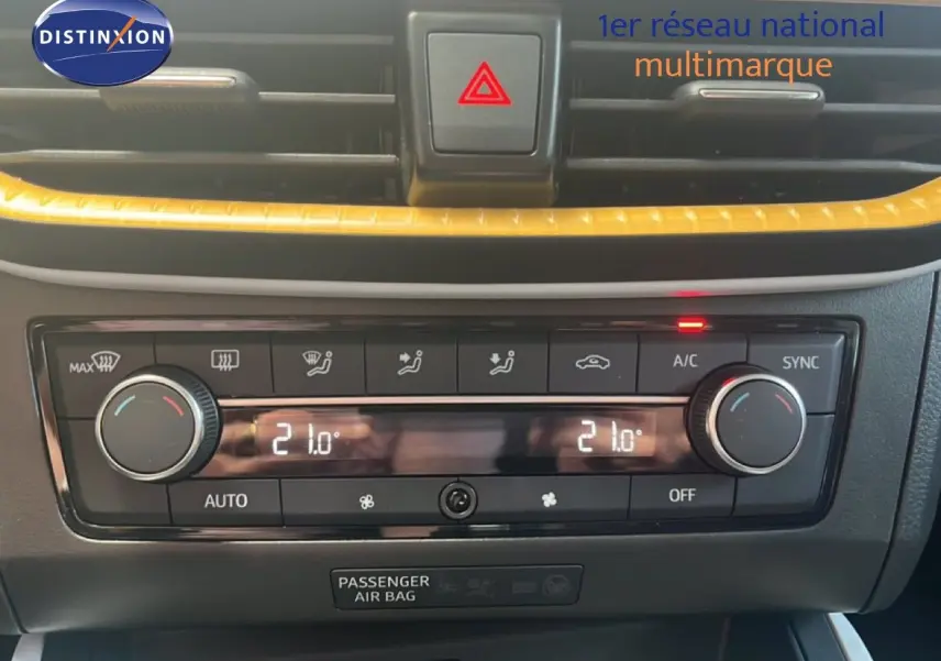 Gros plan sur la console centrale du SEAT Arona 2025, montrant la climatisation automatique avec réglage à 21°C.