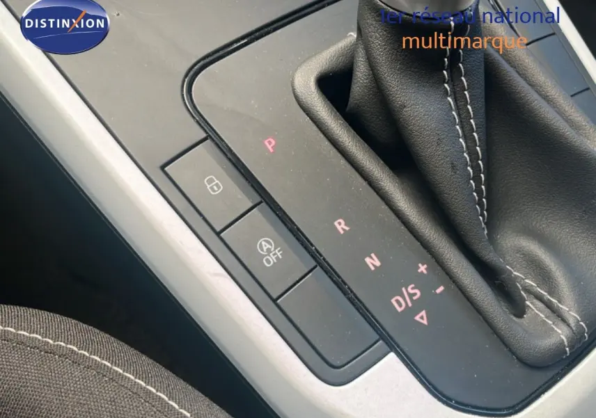 Gros plan sur la console centrale avec levier de vitesses automatique et boutons de commande, intérieur tissu noir.