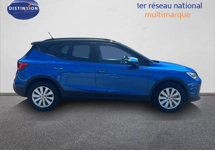 Vue de profil côté gauche d'un SEAT Arona 2025 bleu saphir avec toit noir, roues alliage et carrosserie compacte.