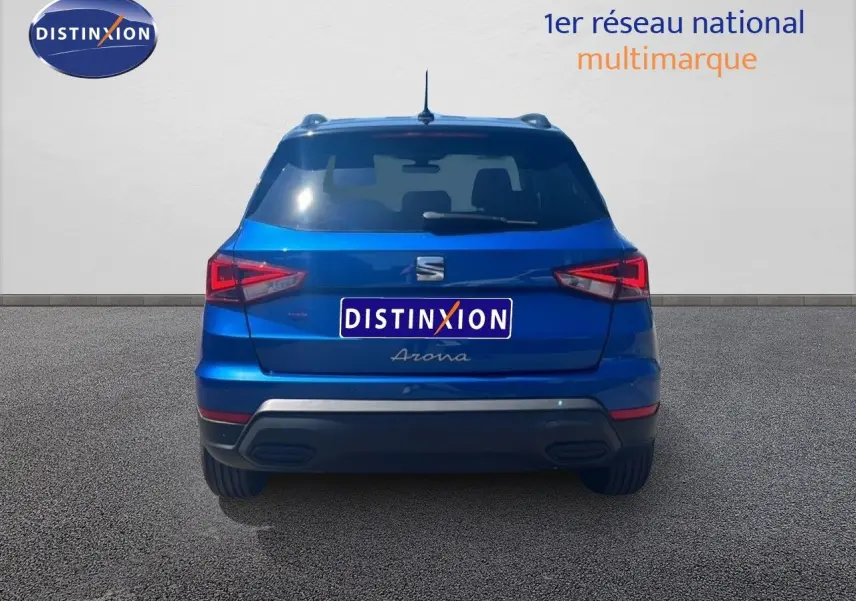 Vue arrière d'un SEAT Arona bleu saphir métal avec toit noir, mettant en valeur ses feux arrière LED et son design compact.