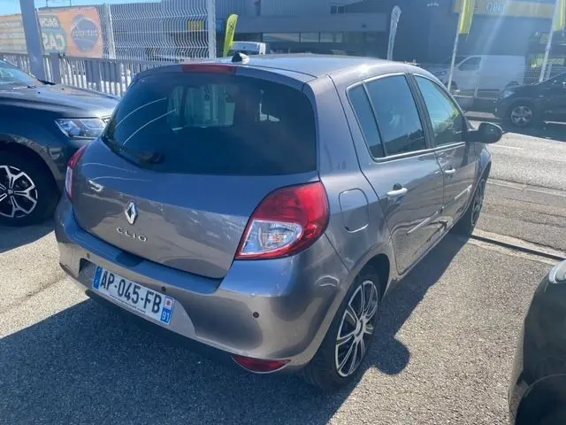 Renault Clio III 110 ch exception tomtom gris métallisé vue 3/4 arrière côté droit sur parking extérieur